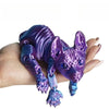 A purple articulated sphynx cat figurine is held in a hand, showcasing its detailed texture and poseable features.