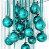 A collection of teal and silver round foil balloons with ribbons hanging vertically.