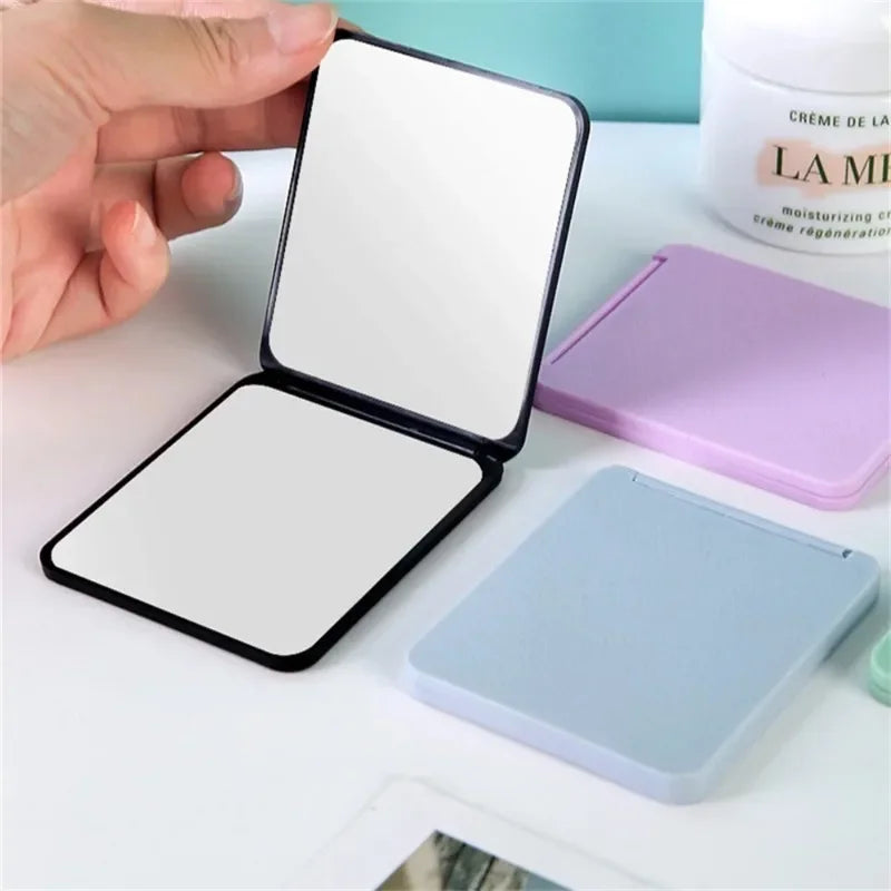 Portables faltbarer Make-up-Spiegel in schwarz und lila/blau, geöffnet und geschlossen.