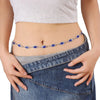 A woman wearing a denim skirt displays a blue crystal waist chain on her abdomen.