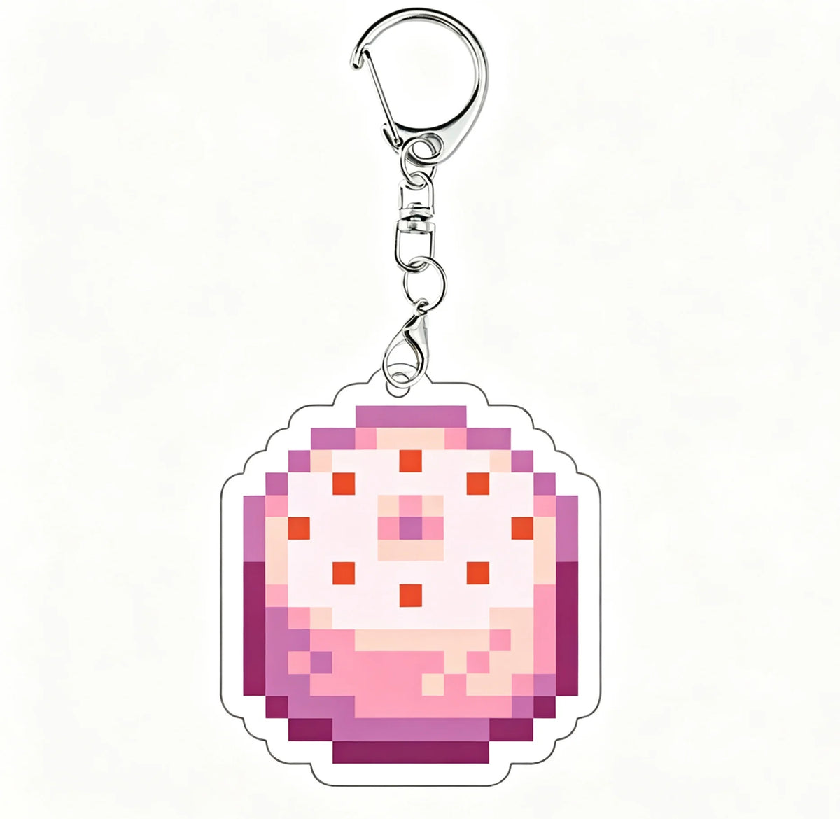 A clear acrylic keychain charm featuring a pixelated design in shades of pink and purple.