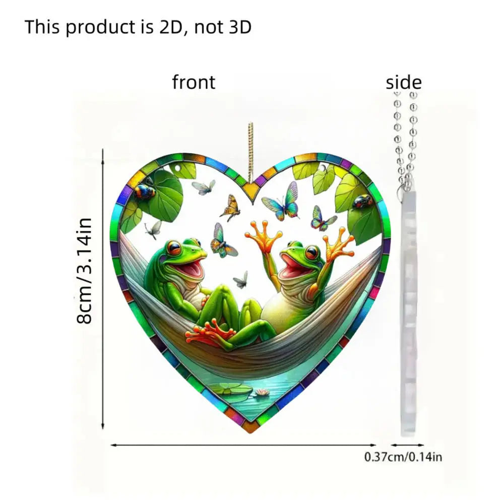 Front view of a 2D heart-shaped acrylic ornament featuring a green frog surrounded by colorful butterflies and leaves.