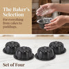 A set of four black nonstick mini fluted cake pans being held by a hand, with baking ingredients visible in the background.