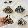 Three leopard print shoulder strap skirts for dolls displayed on a white cloth.