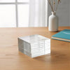 A stack of clear acrylic magnetic sheets for crafts and refrigerator magnets resting on a wooden table.