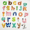 A collection of colorful magnetic alphabet learning magnets including letters, animals, and objects.