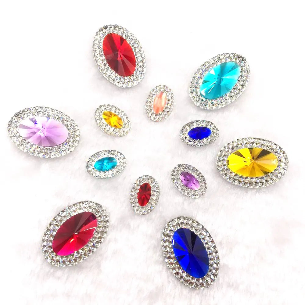 A collection of various colored gemstones, including red, blue, green, and yellow, set in flatback rhinestones.