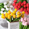 Un ramo de tulipanes de PU artificiales en colores blanco, amarillo y rojo sobre un fondo blanco.