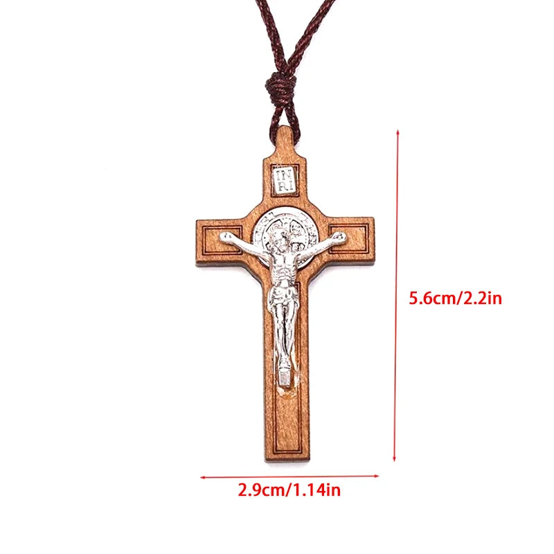 A wooden cross necklace featuring a crucifix design suspended by a wax rope cord.