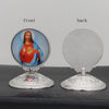A pair of silver-toned tabletop ornaments featuring a front image of Jesus and a back textured disc.