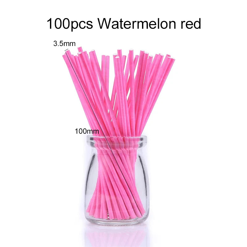 A glass jar filled with 100 pink watermelon red paper lollipop sticks.