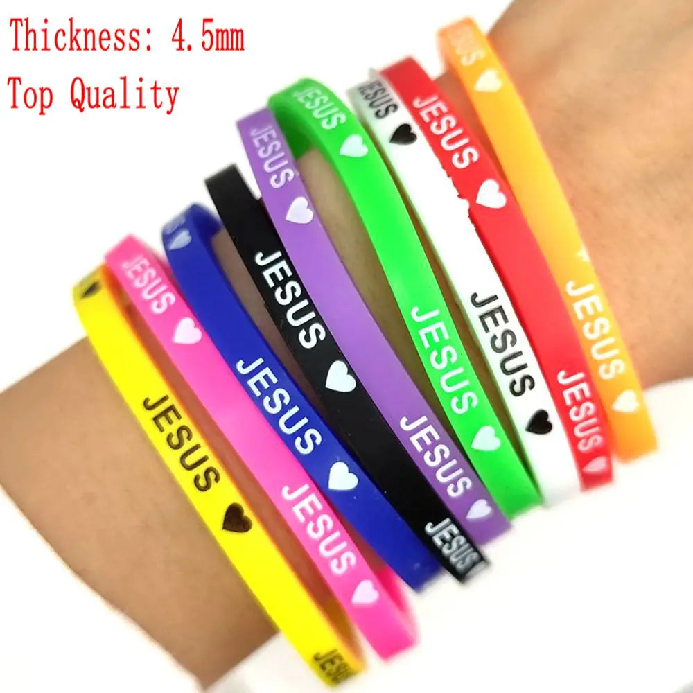 A collection of silicone bracelets featuring the name Jesus with a heart design in various colors