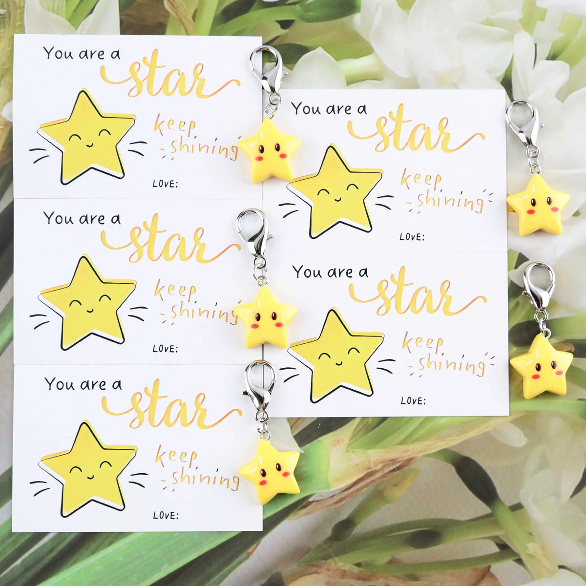 A set of inspirational star keychains featuring yellow and gold stars with handwritten text