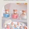 Fluted glass relief soy wax teddy bear candles in various colors displayed on a white plate