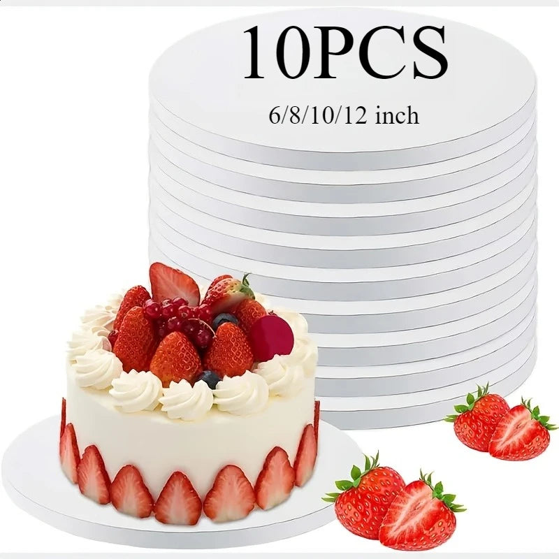 A white frosted cake is displayed in front of a stack of round cake boards, with fresh strawberries and berries around the ba