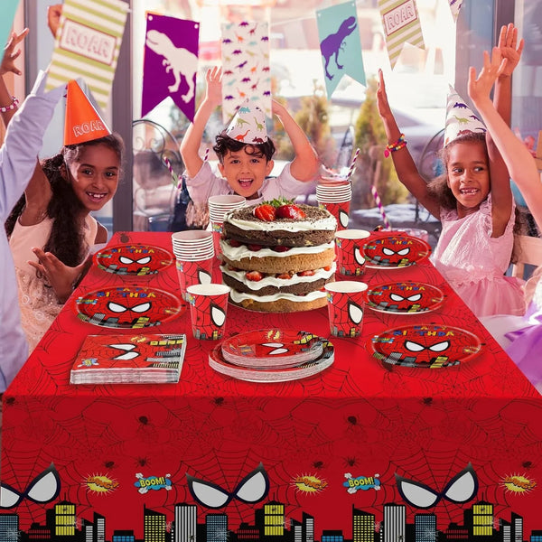 A red table decorated with Spider-Man themes featuring a cake, plates, and party decorations.
