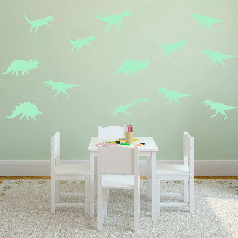 A white wooden dining set with light green glow in the dark dinosaur wall decals on a pale green wall.