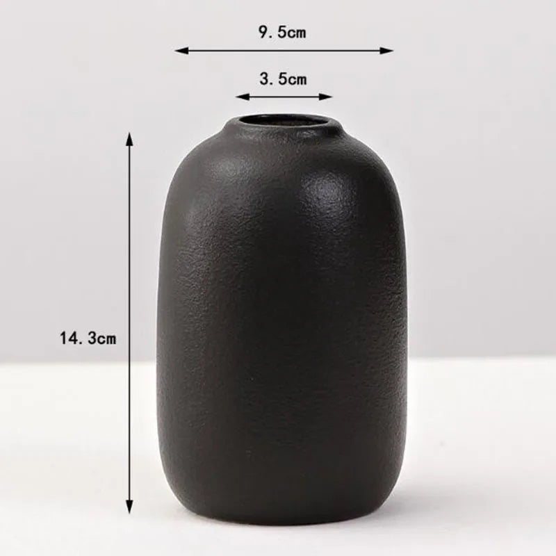 A matte black ceramic vase with a rounded body and a narrow opening, shown against a white background.
