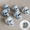 A collection of realistic white skeleton arm stakes for Halloween lawn decor displayed on a beige fabric.