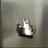 A magnetic acrylic decor featuring a cat head with long whiskers against a brushed metal background.