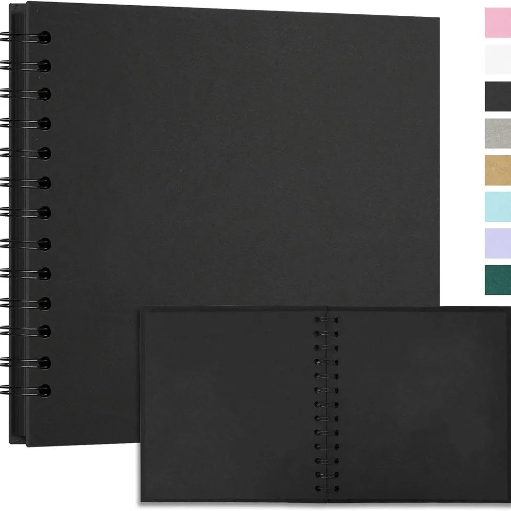 A black spiral-bound notebook or journal with a black cover shown next to a lighter colored palette.
