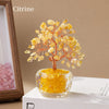A natural crystal money tree ornament featuring yellow citrine crystals on a stem, displayed in a clear glass bowl.