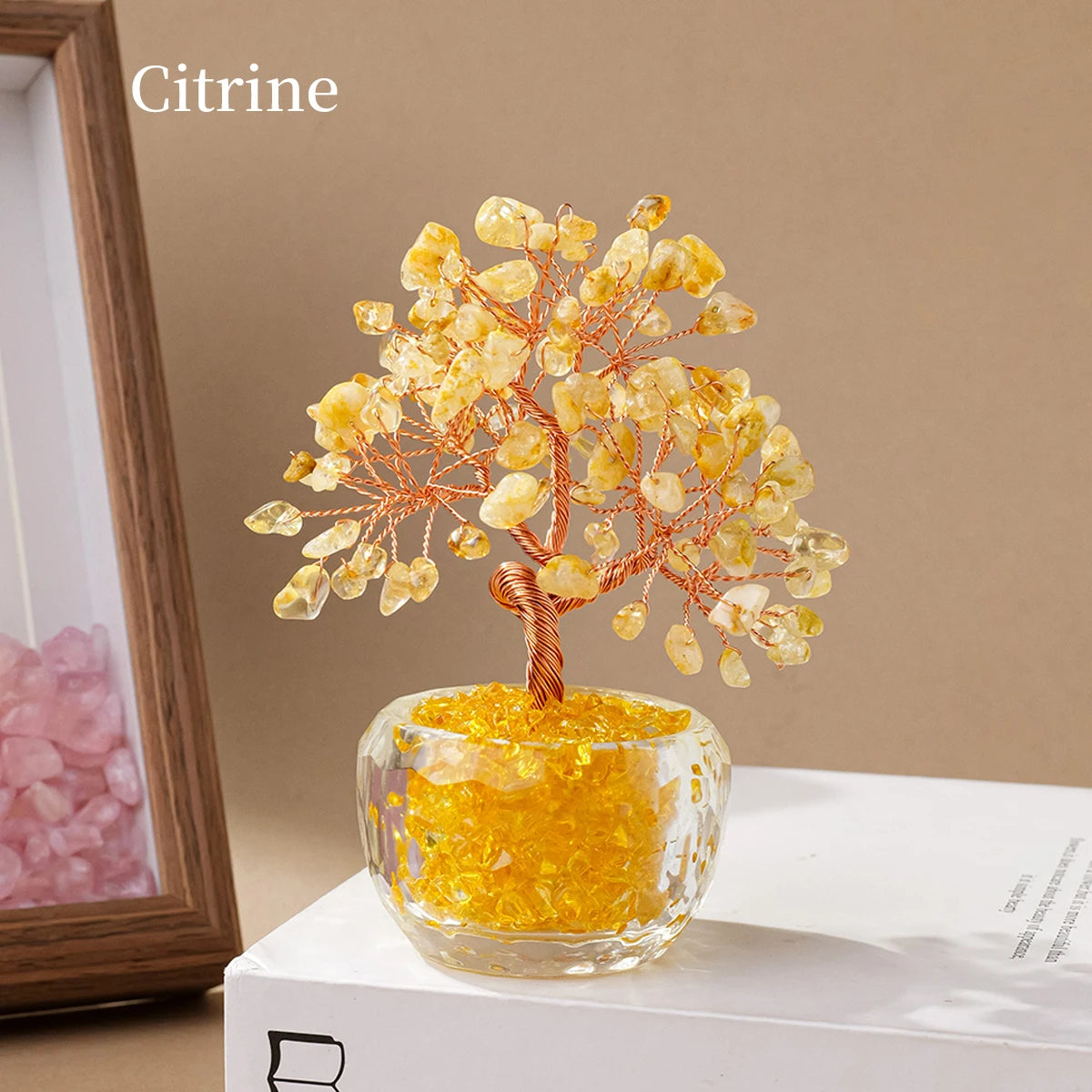A natural crystal money tree ornament featuring yellow citrine crystals on a stem, displayed in a clear glass bowl.