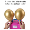 A hand is holding a pink electric balloon pump next to two inflated gold balloons.