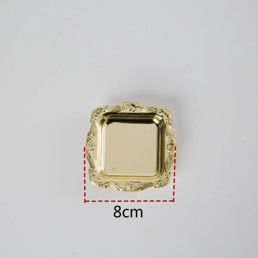 A gold-colored square mini tray with an ornate, scalloped edge.