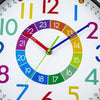 A close-up of a colorful silent wall clock showing the time, with hands pointing to 12:00.