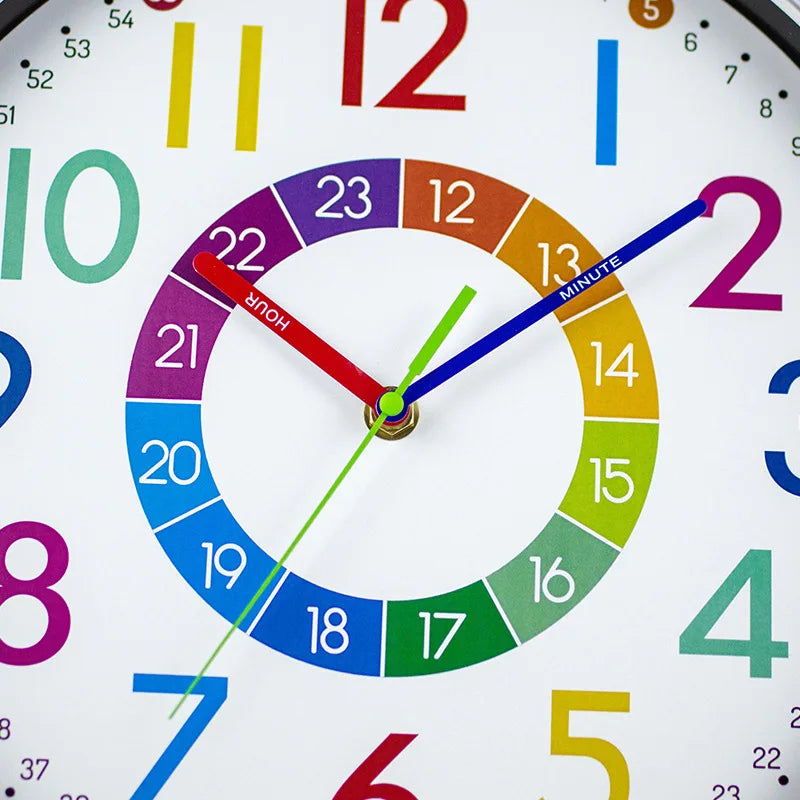 A close-up of a colorful silent wall clock showing the time, with hands pointing to 12:00.