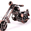 A handcrafted metal motorcycle model with a dark finish and brass accents, shown in profile.