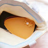 A yellow cartoon PU leather key holder with a pull-out design is shown inside a light blue fabric pouch.