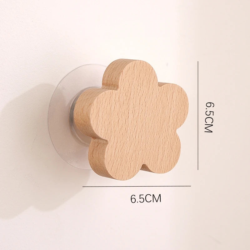 A light wood decorative animal hook with a flower shape mounted on a clear circular base.
