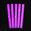 Five vertical glow foam sticks in bright pink light against a dark background.