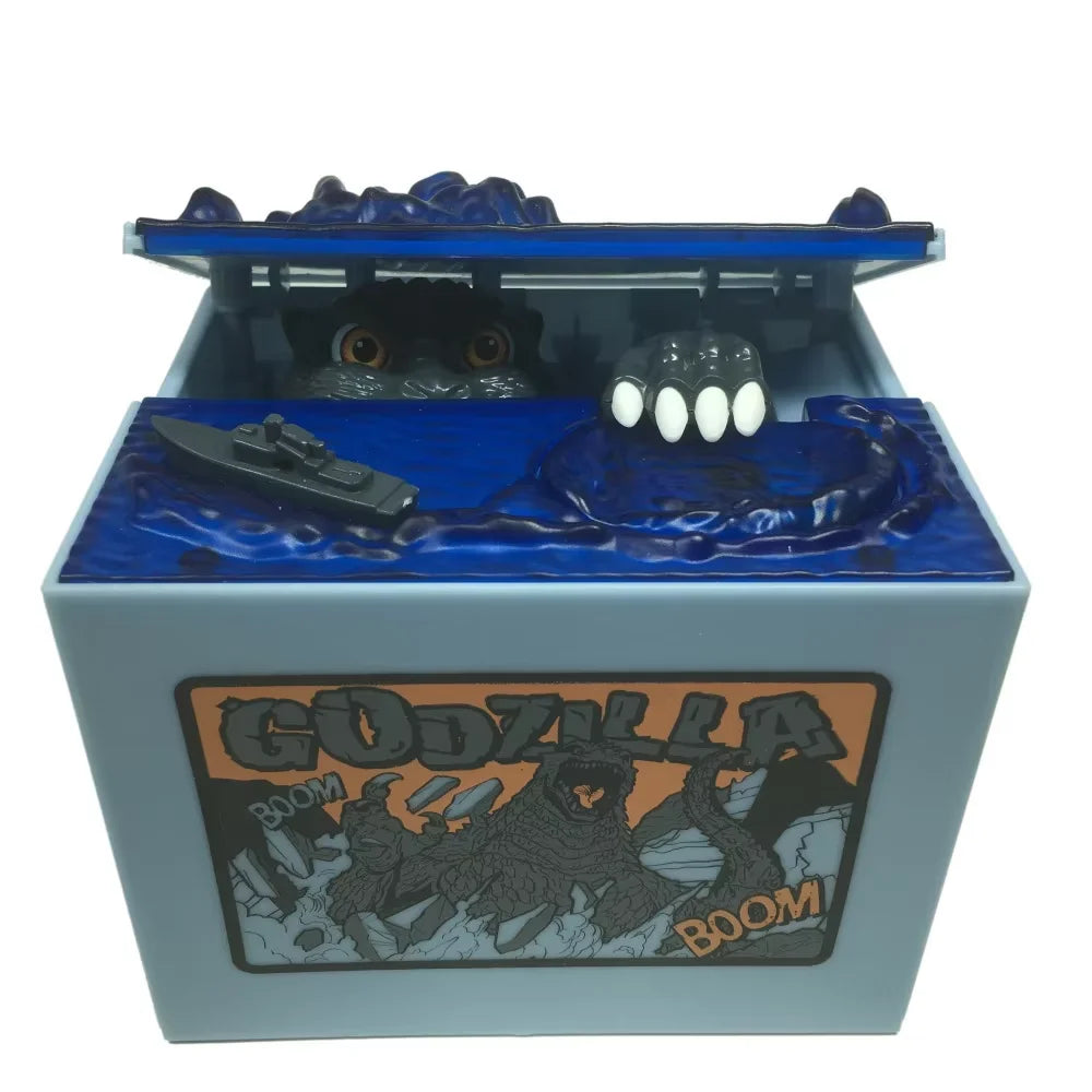 A resin piggy bank shaped like Godzilla, featuring a blue body and an open top revealing a small figure.
