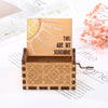 A wooden music box featuring a sun design and intricate geometric patterns, set against a white background.