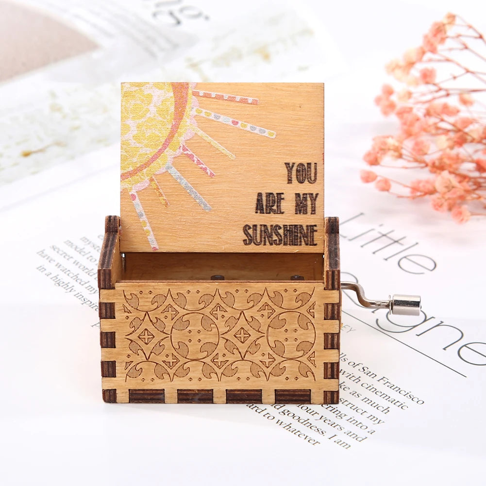 A wooden music box featuring a sun design and intricate geometric patterns, set against a white background.