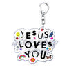 Klares Acryl-Anhänger mit der Aufschrift Jesus liebt dich, umgeben von lächelnden Emojis und einem Schmetterling.