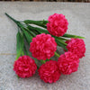 Un bouquet de fleurs d'hydrangea artificielles rose vif posé sur une surface de pierre grise.