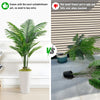 Comparison of an artificial palm tree floor decor plant in a white pot versus a small flower pot that falls over.