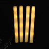 Five vertical glow foam sticks emitting a warm yellow light against a dark background.