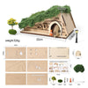 A brown wooden fairy house model featuring an arched door and a tooth box, with accompanying assembly instructions.