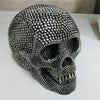 A realistic silver skull resin decorative sculpture with a textured surface.
