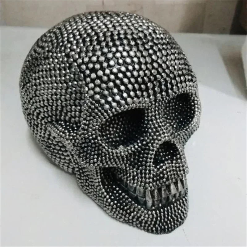 A realistic silver skull resin decorative sculpture with a textured surface.