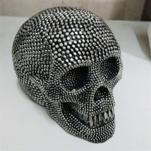 A realistic silver skull resin decorative sculpture with a textured surface.