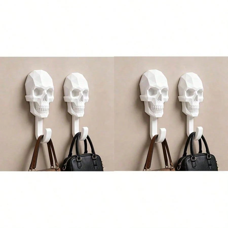 Four white skull wall hooks with leather straps are displayed against a beige background.