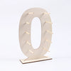 A light wood display stand shaped like the number zero, designed to hold desserts.