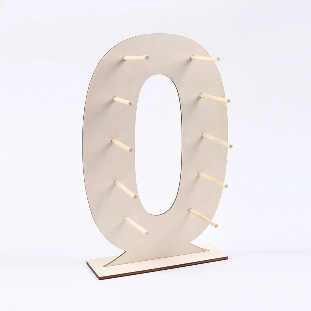 A light wood display stand shaped like the number zero, designed to hold desserts.
