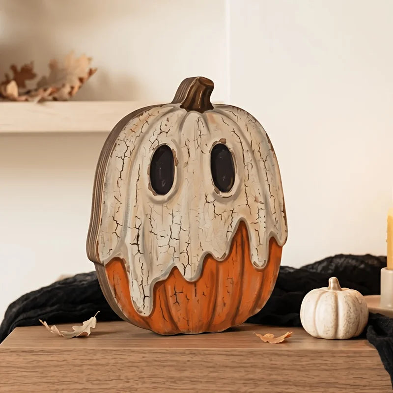 A distressed, orange and white vintage carved pumpkin decor set sitting on a wooden surface.